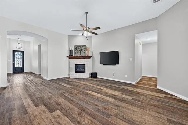 a view of a livingroom with a flat screen tv ceiling fan and a fireplace
