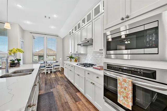 a kitchen with stainless steel appliances a stove sink and cabinets