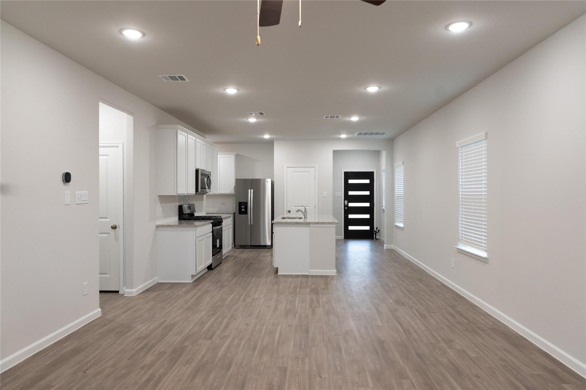 64 Valiant Ridge Trail Magnolia, TX 77354 - Photo 1 of 33 a view of a kitchen with refrigerator microwave and wooden floor