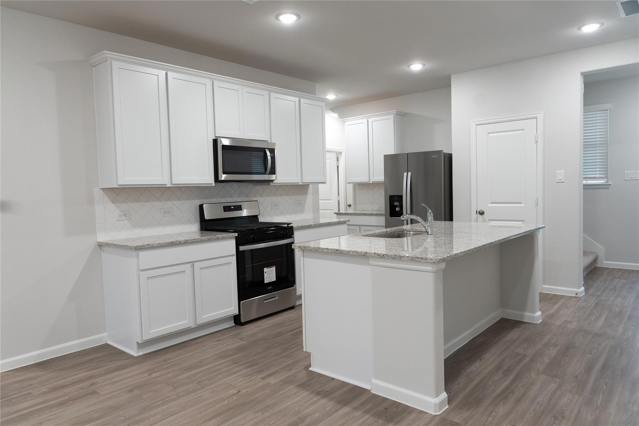 64 Valiant Ridge Trail Magnolia, TX 77354 - Photo 5 of 33 a kitchen with granite countertop white cabinets sink and stainless steel appliances