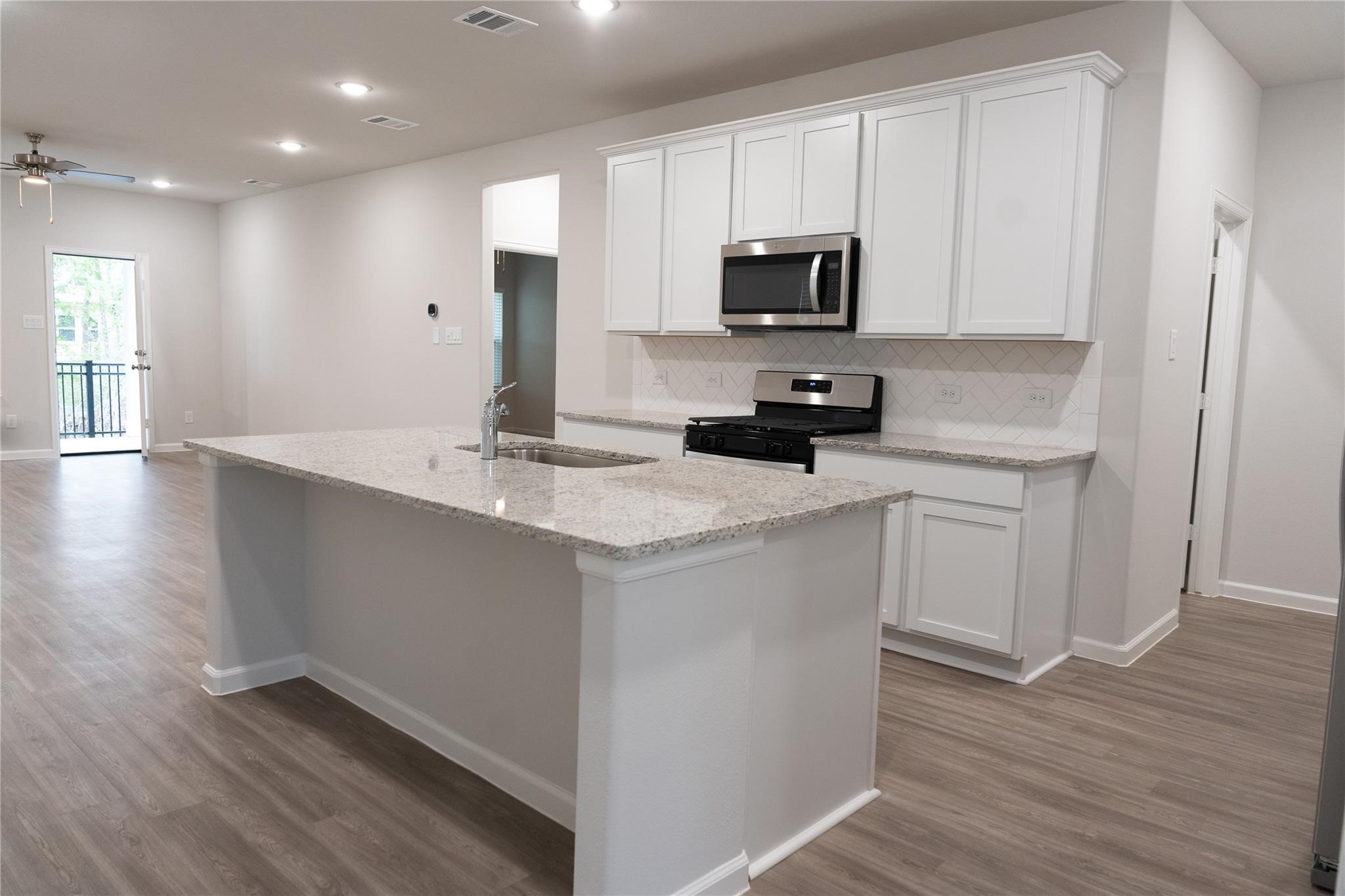 64 Valiant Ridge Trail Magnolia, TX 77354 - Photo 6 of 33 a kitchen with a sink microwave and cabinets