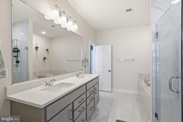 a bedroom with a large bed chandelier and a window