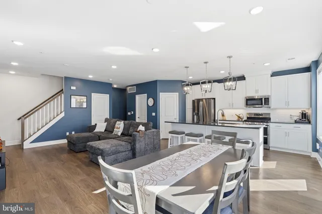 a kitchen with stainless steel appliances kitchen island granite countertop a sink a stove a refrigerator and cabinets