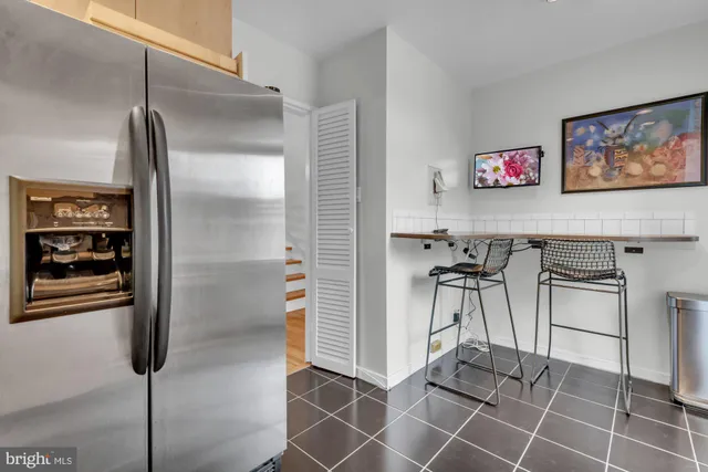 a dinning room with stainless steel appliances kitchen island granite countertop a refrigerator and a cabinets