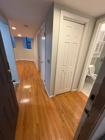 a view of a hallway with wooden floor and staircase