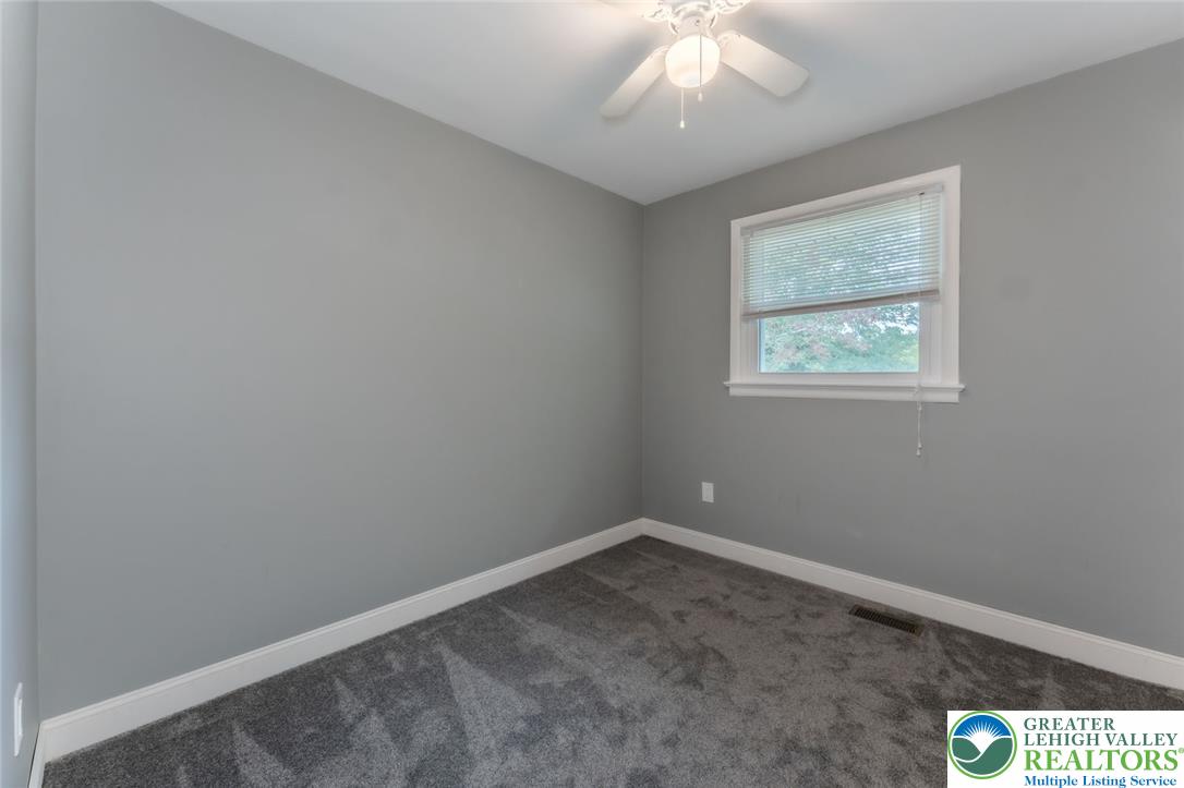 402 Maple Street Roseto, PA 18013 - Photo 21 of 39 A quiet bedroom features plush carpeting and a classic wood-framed window.