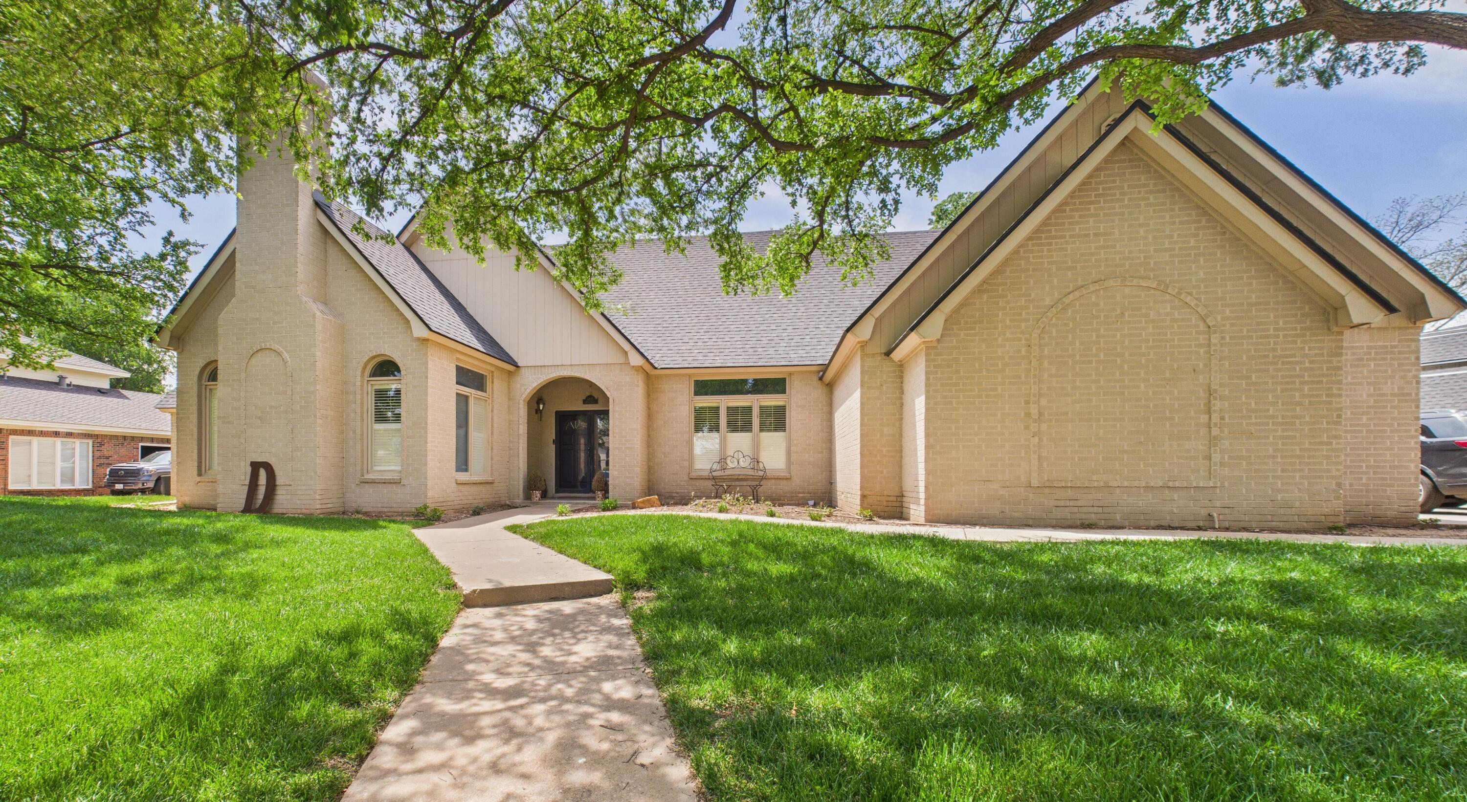 4615 94th Street Lubbock, TX 79424 - Photo 2 of 82 a view of a yard in front of a house with a large tree