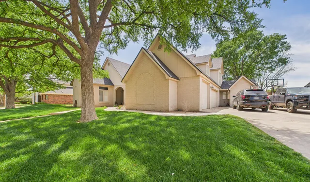 a view of a house with backyard and a tree