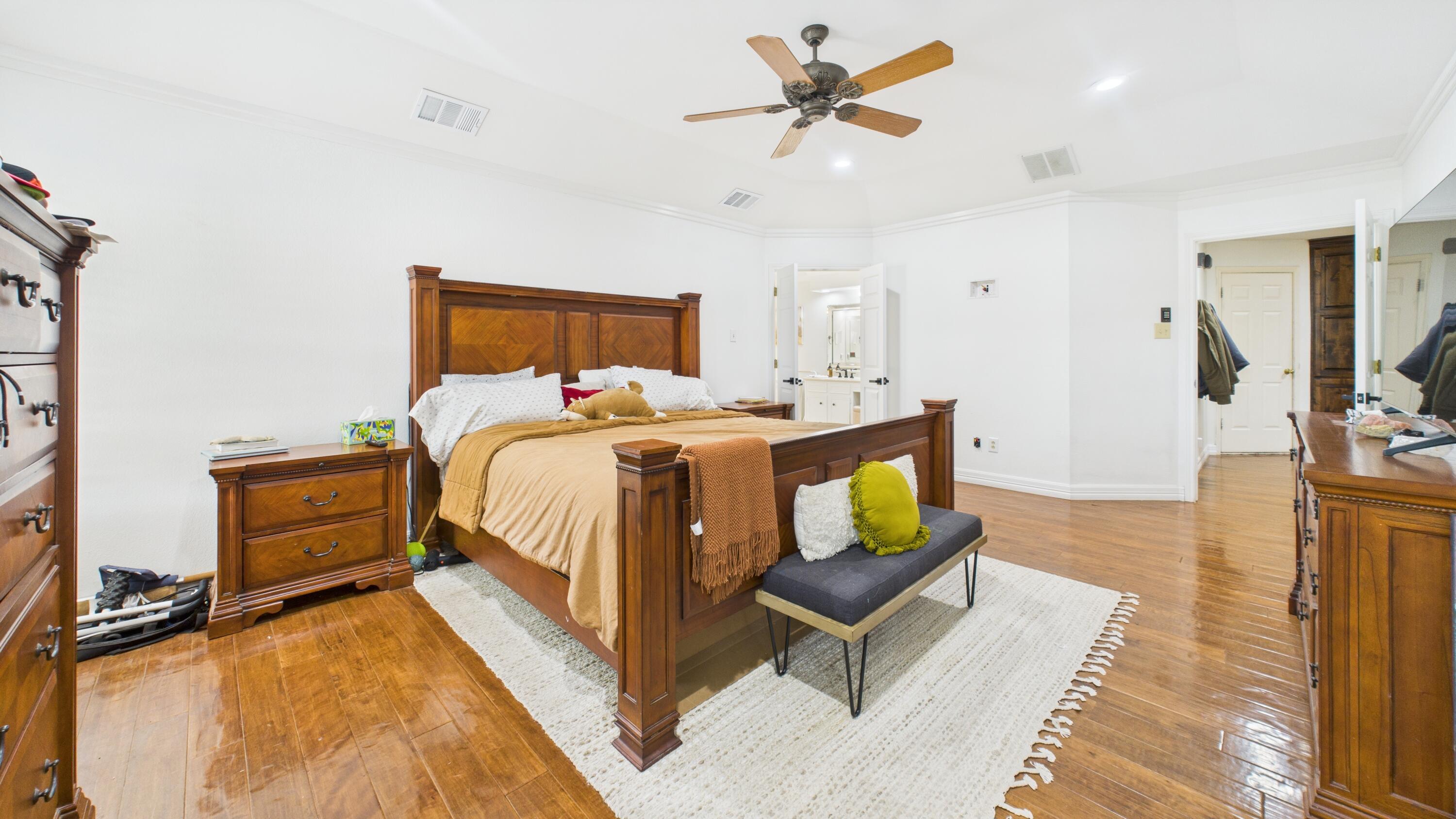 4615 94th Street Lubbock, TX 79424 - Photo 55 of 82 a bed room with a bed a couch and a chandelier