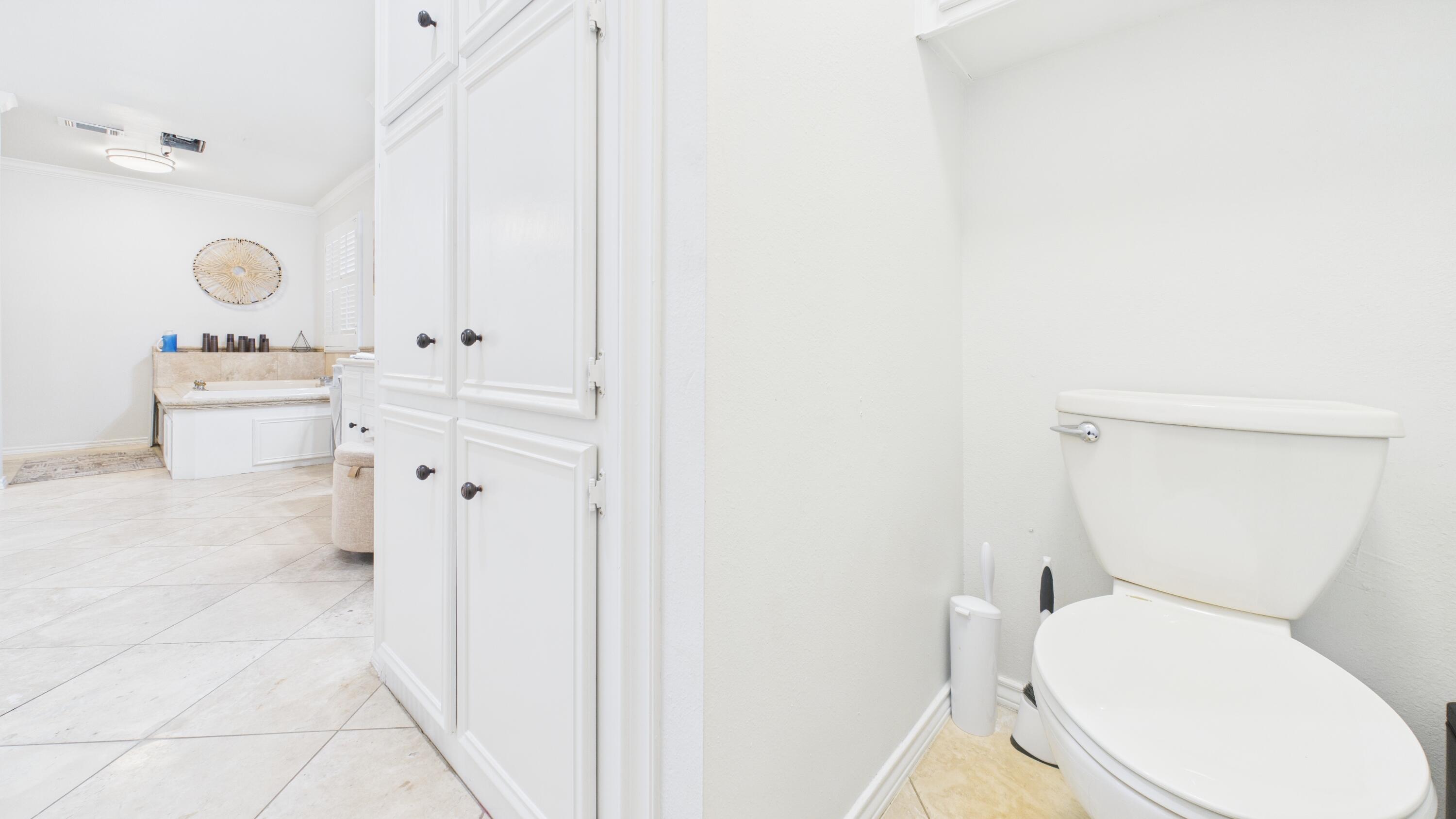 4615 94th Street Lubbock, TX 79424 - Photo 59 of 82 a white toilet sitting next to a bathroom sink