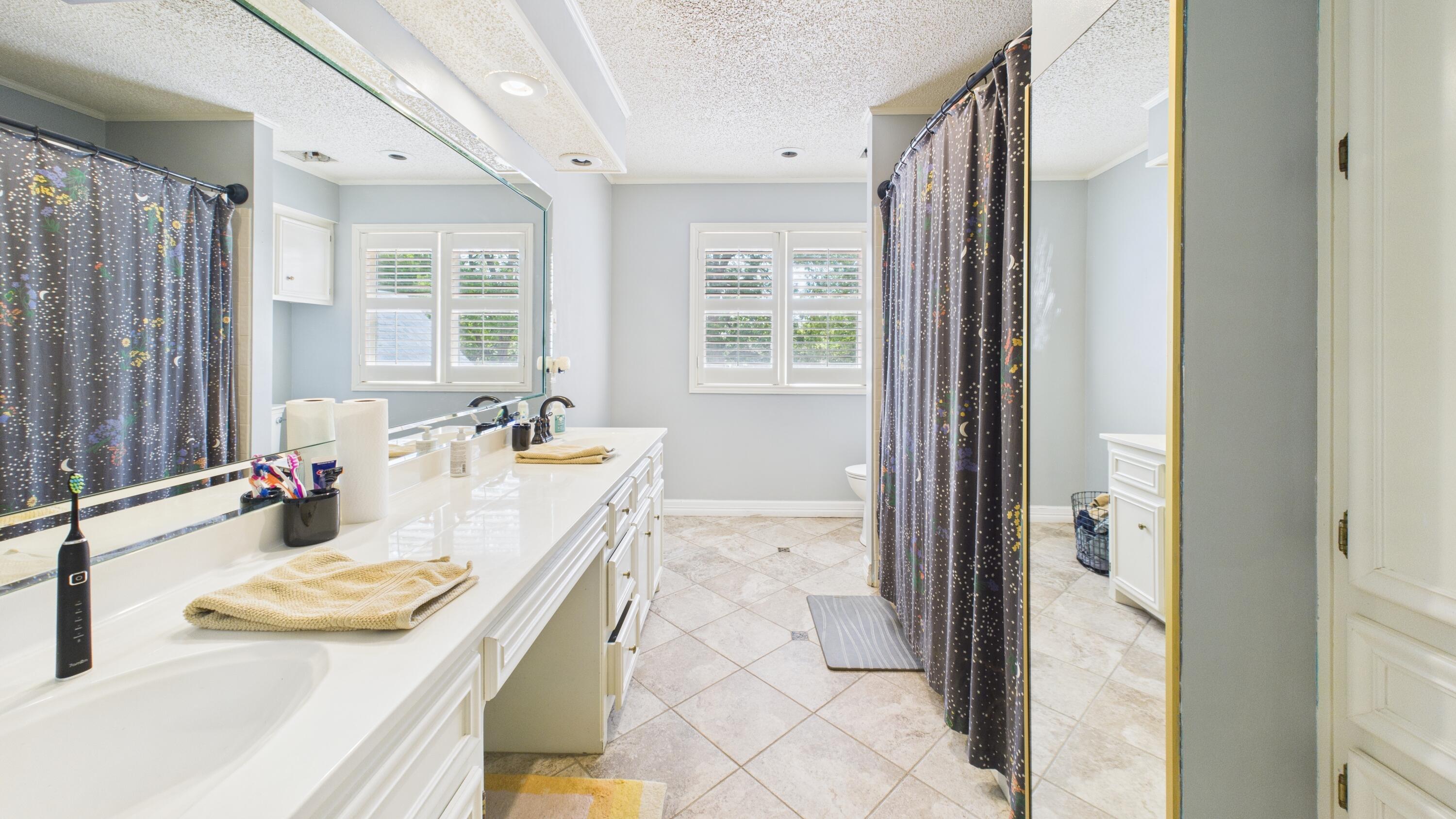 4615 94th Street Lubbock, TX 79424 - Photo 64 of 82 a bath room with a granite countertop sink and a mirror