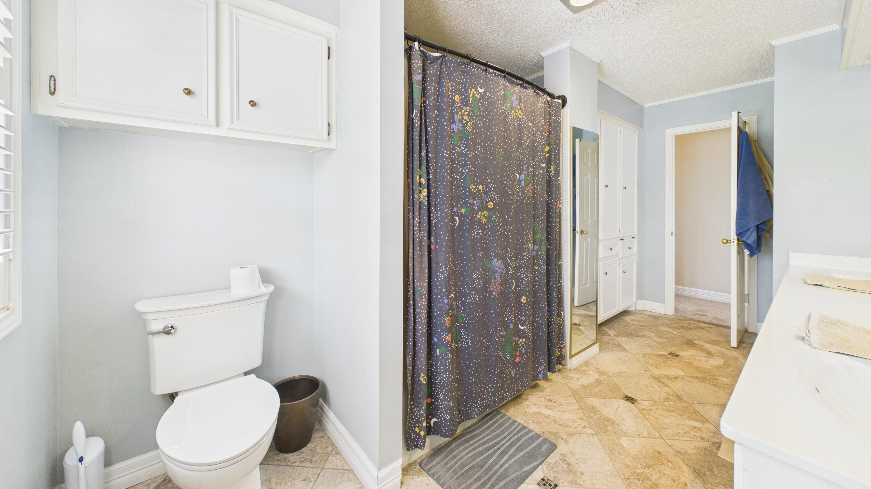 4615 94th Street Lubbock, TX 79424 - Photo 65 of 82 a bathroom with a toilet a sink and a shower