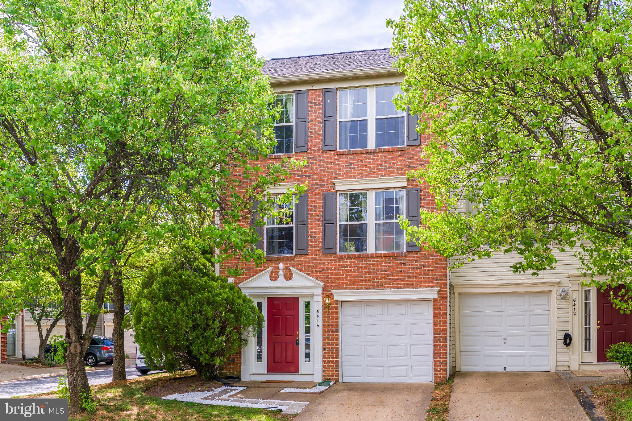 a front view of a building with trees