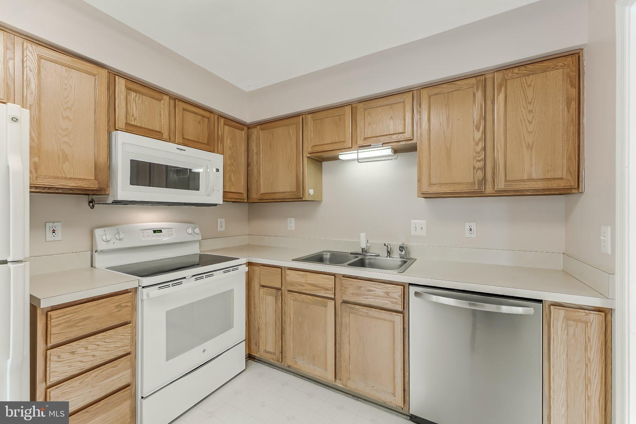 6414 Lureta Ann Lane Springfield, VA 22150 - Photo 7 of 44 a kitchen with white cabinets sink and stainless steel appliances