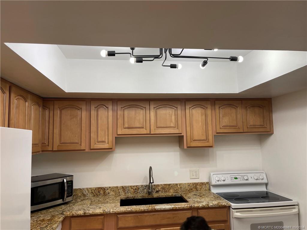 1900 South Kanner Highway, Unit 9202 Stuart, FL 34994 - Photo 11 of 55 a kitchen with stainless steel appliances granite countertop a sink a stove and cabinets