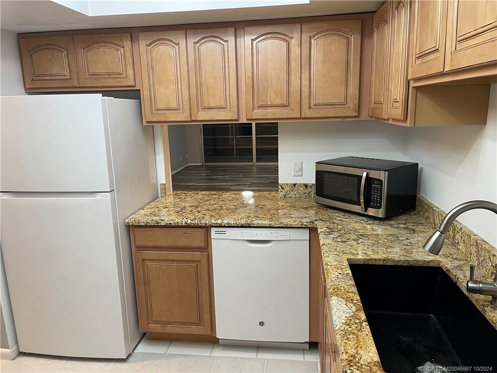 1900 South Kanner Highway, Unit 9202 Stuart, FL 34994 - Photo 14 of 55 a kitchen with granite countertop cabinets stainless steel appliances and a sink