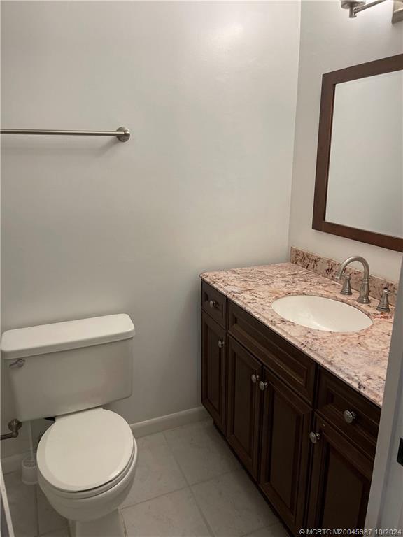 1900 South Kanner Highway, Unit 9202 Stuart, FL 34994 - Photo 37 of 55 a bathroom with a granite countertop toilet sink and mirror
