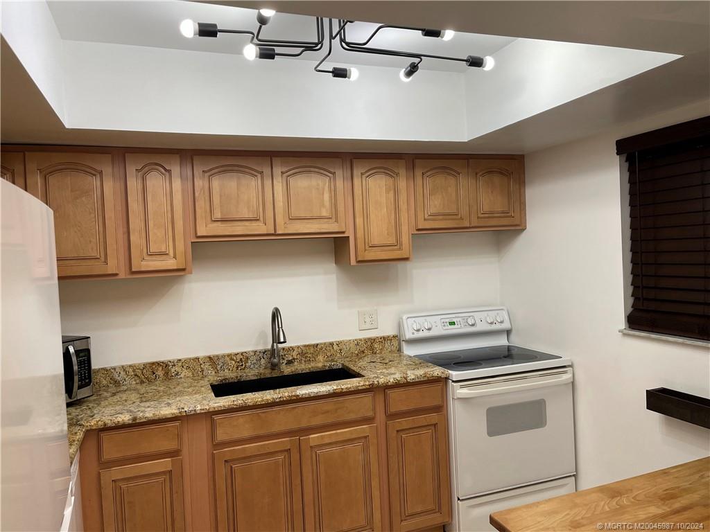 1900 South Kanner Highway, Unit 9202 Stuart, FL 34994 - Photo 9 of 55 a kitchen with stainless steel appliances granite countertop a sink a stove and cabinets