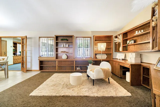 a living room with couches and kitchen view with wooden floor