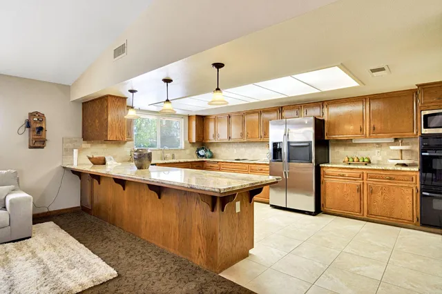 a kitchen with stainless steel appliances granite countertop a refrigerator sink and cabinets