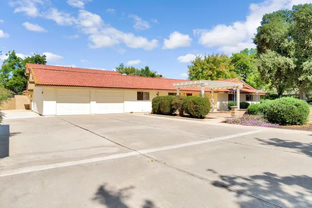 a view of a white house with a yard and potted plants