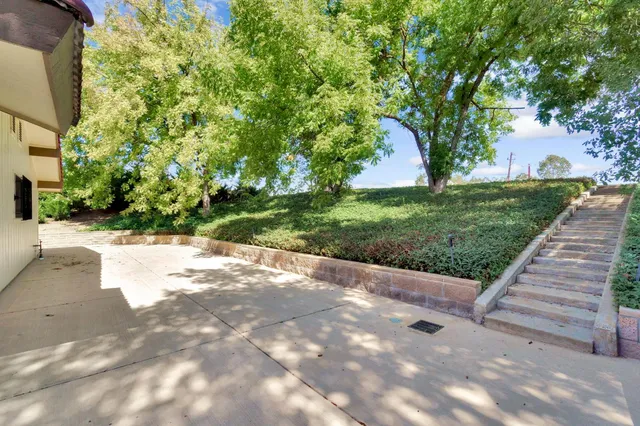 an aerial view of residential house with outdoor space and trees all around