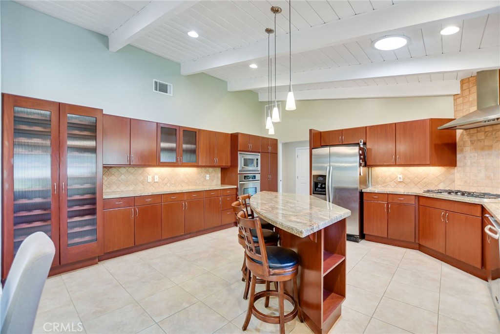 5531 Cornwall Avenue Riverside, CA 92506 - Photo 12 of 69 a kitchen with stainless steel appliances kitchen island granite countertop a table chairs sink and wooden cabinets