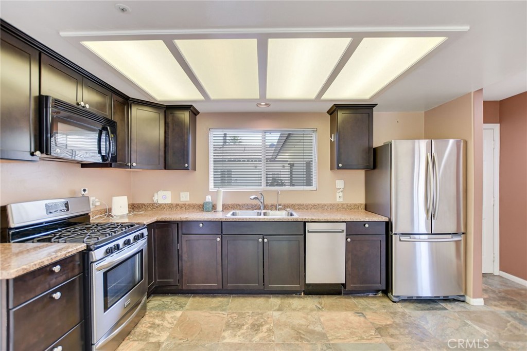 5531 Cornwall Avenue Riverside, CA 92506 - Photo 44 of 69 a kitchen with stainless steel appliances granite countertop a stove a sink dishwasher a refrigerator and a microwave