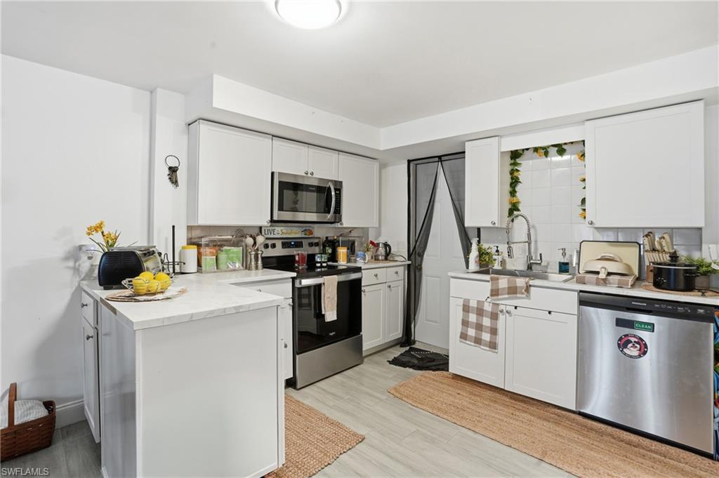 5474 Oak Ridge Avenue Fort Myers Beach, FL 33931 - Photo 13 of 50 a kitchen with a sink a stove top oven and cabinets