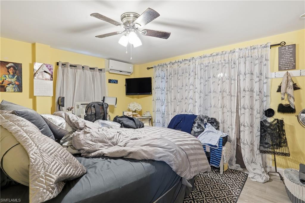 5474 Oak Ridge Avenue Fort Myers Beach, FL 33931 - Photo 15 of 50 a bedroom with a bed couch and a window