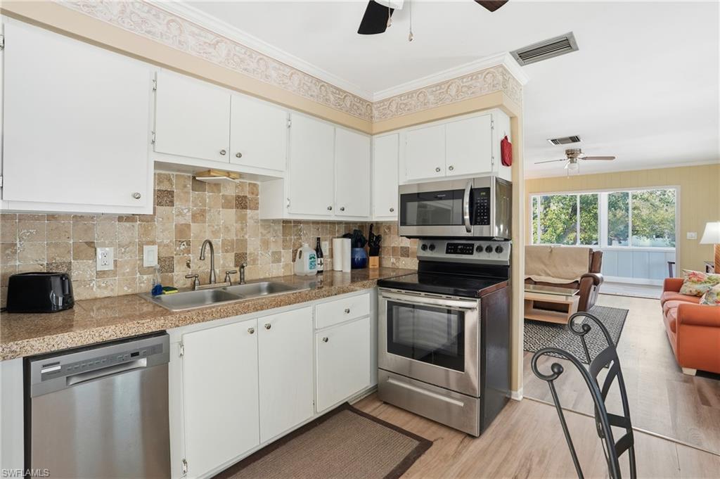 5474 Oak Ridge Avenue Fort Myers Beach, FL 33931 - Photo 30 of 50 a kitchen with granite countertop a sink appliances and cabinets
