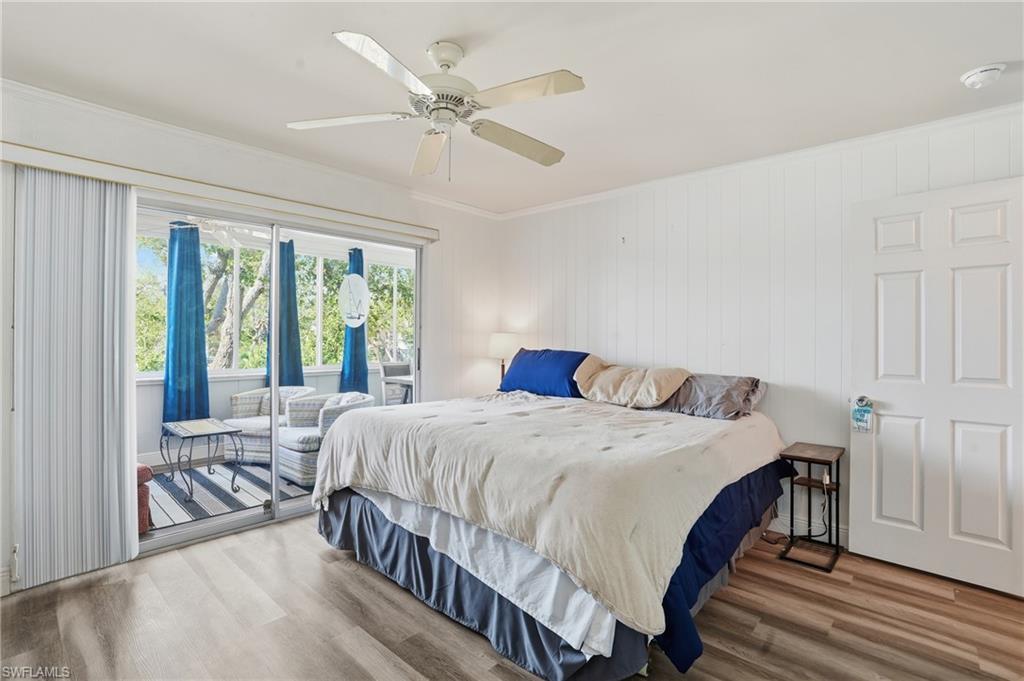 5474 Oak Ridge Avenue Fort Myers Beach, FL 33931 - Photo 32 of 50 a bedroom with a bed a large window and a balcony