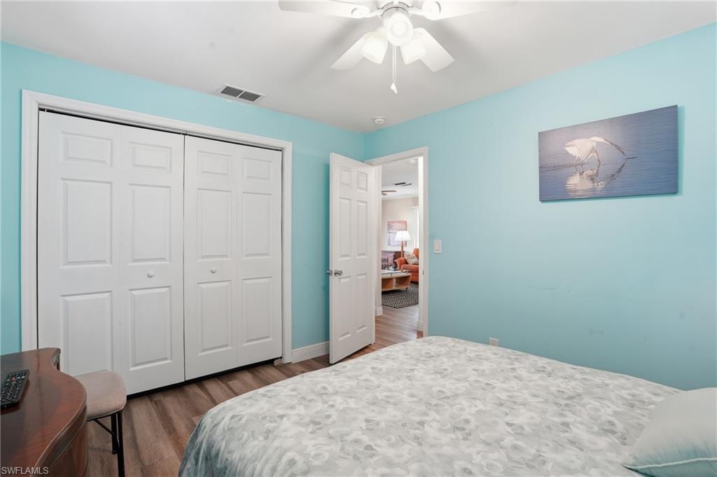 5474 Oak Ridge Avenue Fort Myers Beach, FL 33931 - Photo 35 of 50 a bedroom with a bed and a chandelier