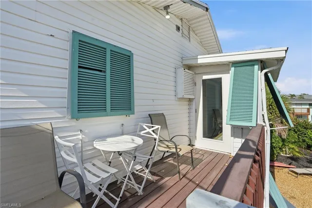 a balcony with wooden floor and outdoor seating