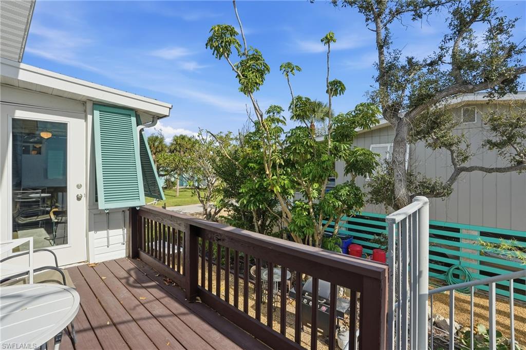 5474 Oak Ridge Avenue Fort Myers Beach, FL 33931 - Photo 41 of 50 a balcony with wooden floor and outdoor seating