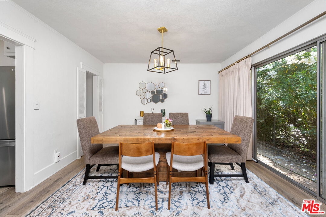 1732 Fiske Avenue Pasadena, CA 91104 - Photo 7 of 23 a dining room with wooden floor a chandelier a wooden table and chairs