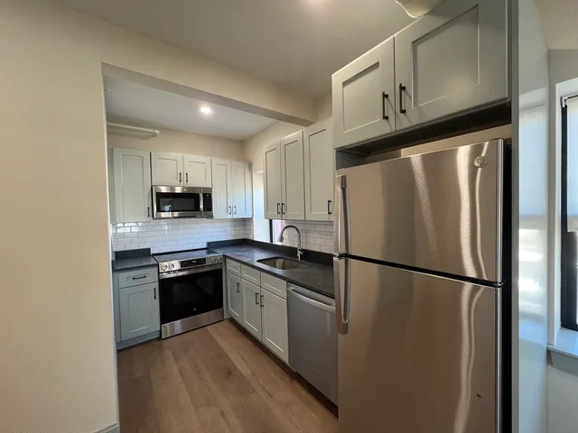 a kitchen with stainless steel appliances granite countertop a refrigerator stove a sink and dishwasher
