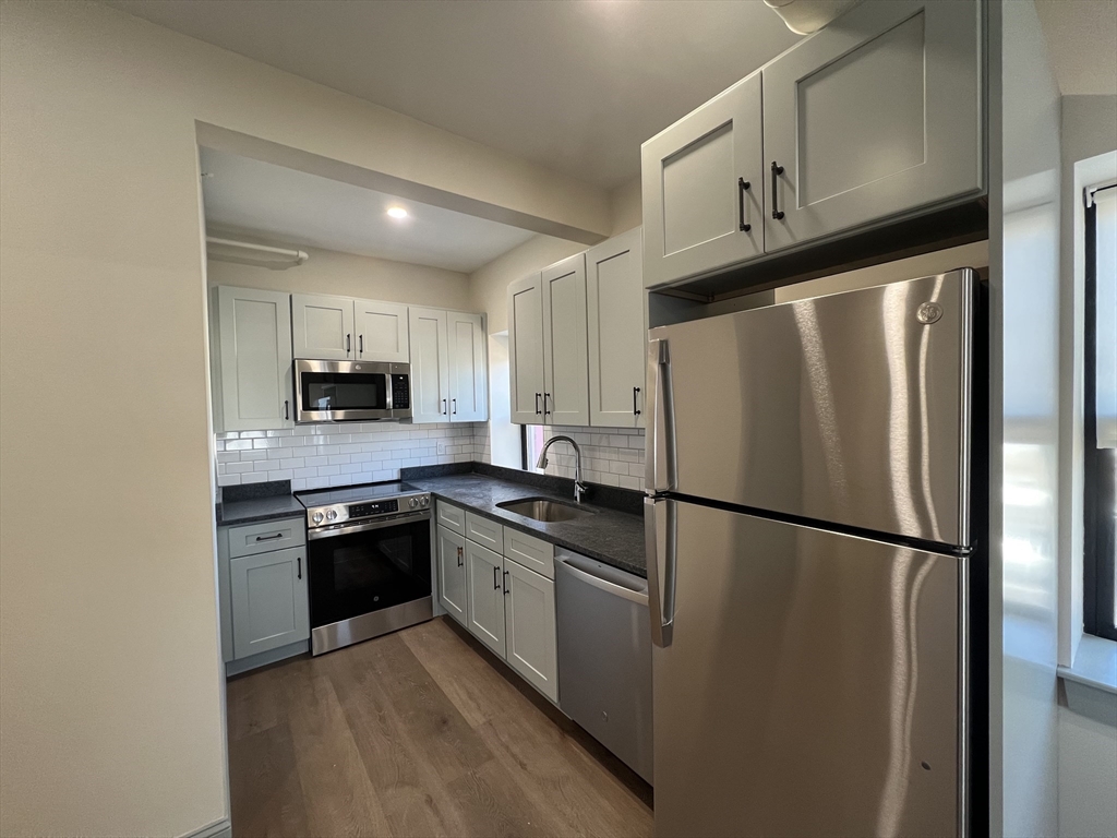 a kitchen with stainless steel appliances granite countertop a refrigerator stove a sink and dishwasher