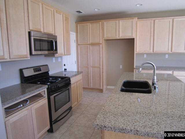 2540 Country Falls Lane Reno, NV 89521 - Photo 2 of 13 a kitchen with granite countertop a sink and a stove top oven