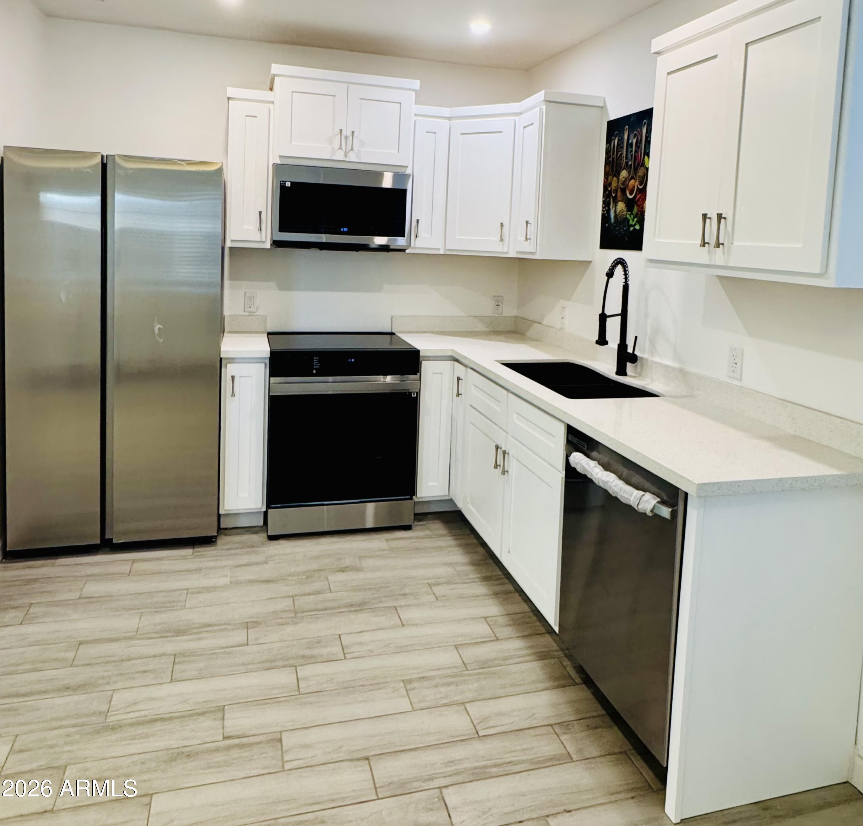 1409 North 5th Street Phoenix, AZ 85004 - Photo 4 of 9 a kitchen with stainless steel appliances granite countertop a stove a sink and a refrigerator