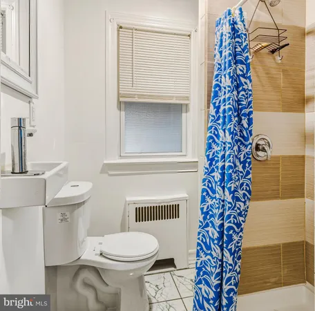 a bathroom with a toilet and a shower curtain