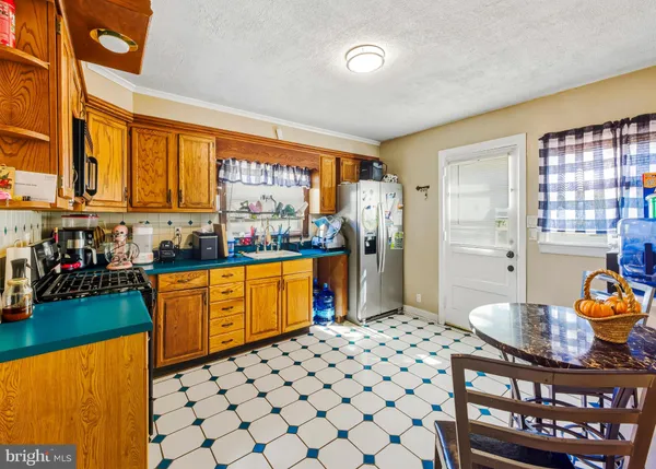 a kitchen with stainless steel appliances kitchen island granite countertop a refrigerator and a stove