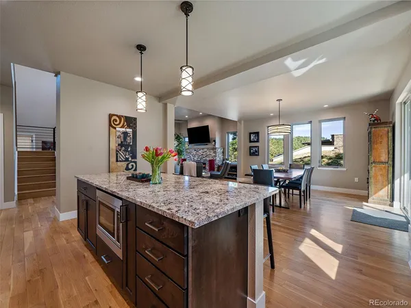 a kitchen with stainless steel appliances granite countertop a kitchen island a stove and a wooden floors
