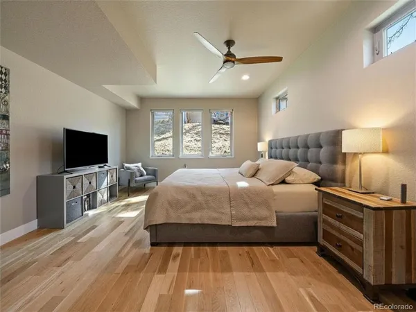 a spacious bedroom with a bed and a flat screen tv