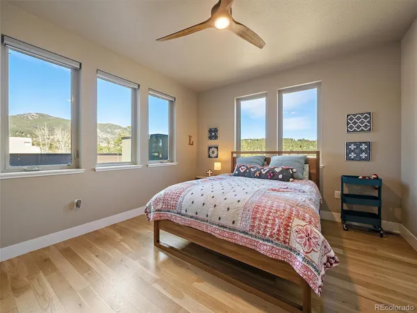 a bedroom with a bed and a dresser with the wooden floor