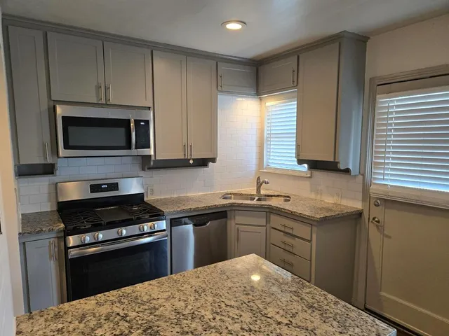 a kitchen with a sink stove and microwave