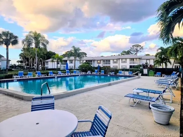 a swimming pool with outdoor seating and lake view