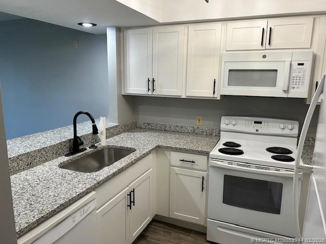 803 Southeast Central Parkway, Unit 5 Stuart, FL 34994 - Photo 3 of 19 a kitchen with white cabinets and sink
