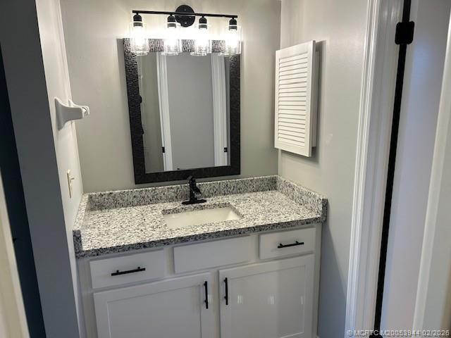 803 Southeast Central Parkway, Unit 5 Stuart, FL 34994 - Photo 10 of 19 a bathroom with a granite countertop sink and a mirror