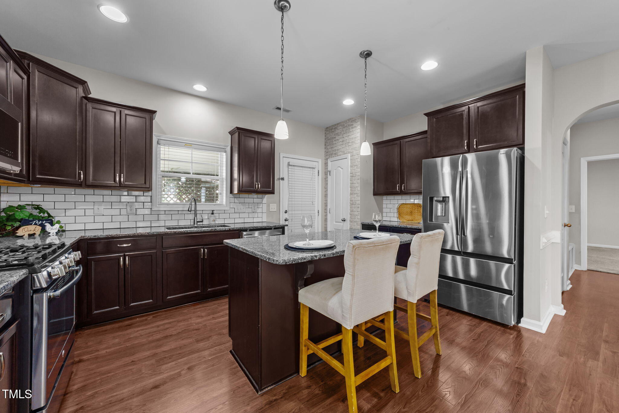 83 Mariners Point Way Garner, NC 27529 - Photo 6 of 49 a kitchen with a refrigerator a stove top oven a sink dishwasher with a dining table and chairs